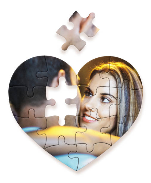 the puzzle of romance: young couple on a heart-shaped jigsaw, with one final piece left to fit - human face heterosexual couple women men imagens e fotografias de stock