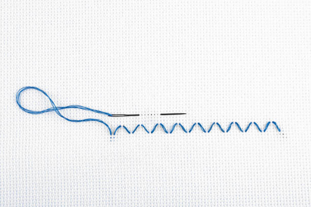 istock Embroidery stitches made with blue thread and needle on canvas, top view 1445400638