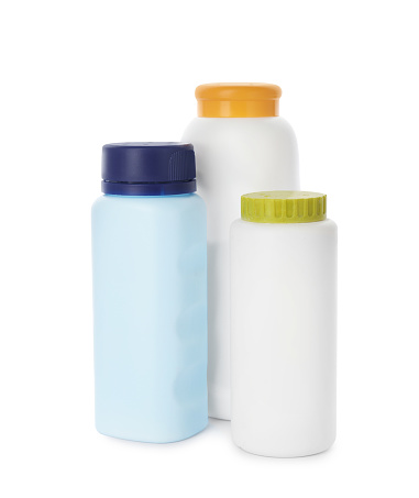 Bottles of dusting powder on white background, space for design. Baby cosmetic product