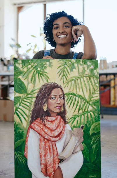 istock Art, portrait and woman with pride in her painting while working at a creative studio. Happy Indian artist, designer or painter while watercolor design with paint on canvas in a professional workshop 1445401384