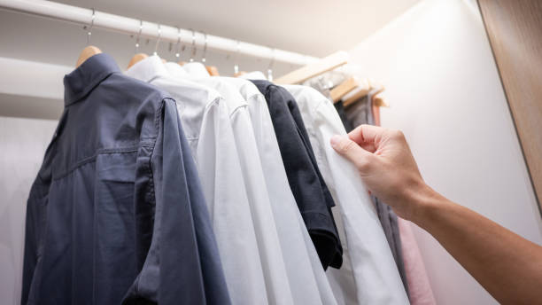 Male hand choosing shirt in closet