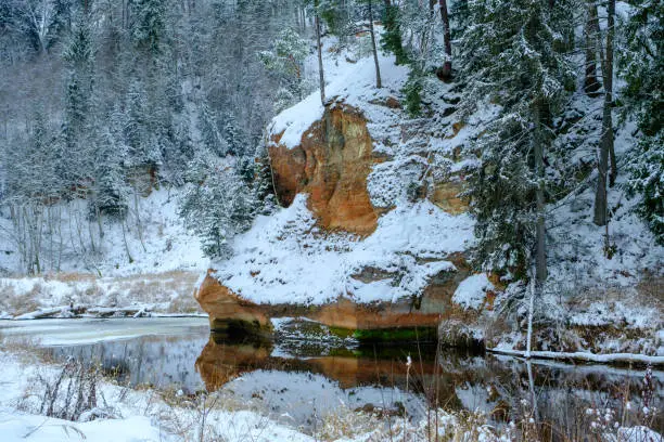 Photo of Sandstone rock. Zvartes rocks on the banks of the Amata River, on a white, snowy and cold winter day, Gauja National Park, Latvia
