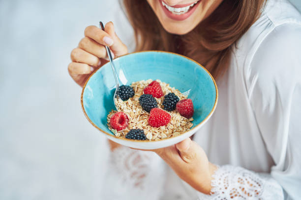 istock Nice brunette on bed wit cereal breakfast with phone 1445403187