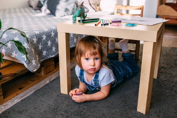 istock Little child playing hide and seek at home under the children's table. 1445404199