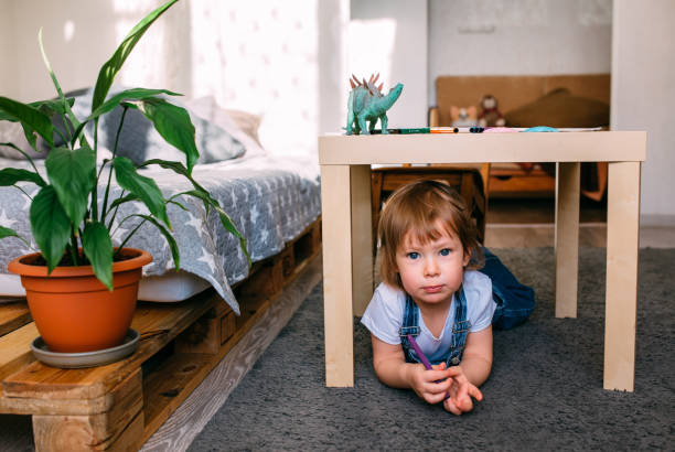 istock Little child playing hide and seek at home under the children's table. 1445404208