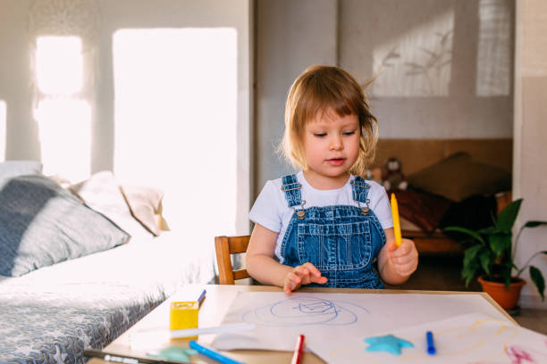 istock Small child at home at the children's table draws with felt-tip pens. 1445404276