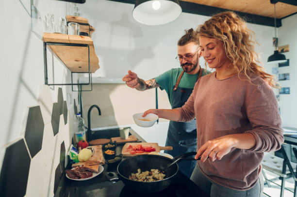 istock Young couple making breakfast together in the kitchen at home 1445405279