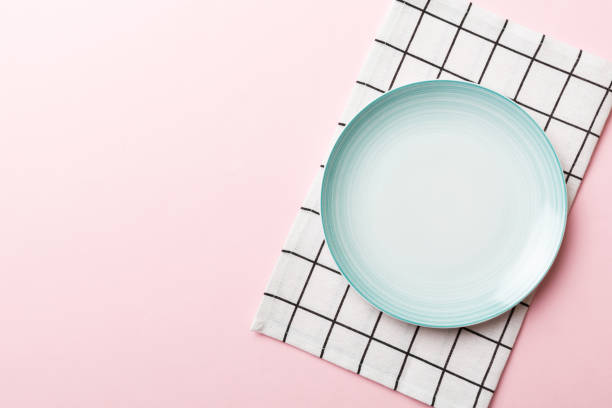 istock Top view on colored background empty round blue plate on tablecloth for food. Empty dish on napkin with space for your design 1445408283