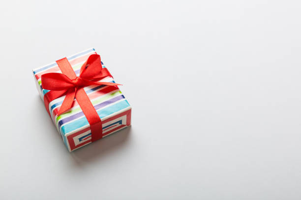 istock Wrapped christmas or other holiday handmade present in paper with colored ribbon. Present box, decoration of gift on table, top view with copy space 1445408317