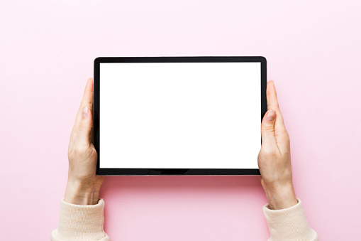 female teen hands using tablet pc with white screen, Mockup image of woman hand holding white tablet pc with blank white screen at home.