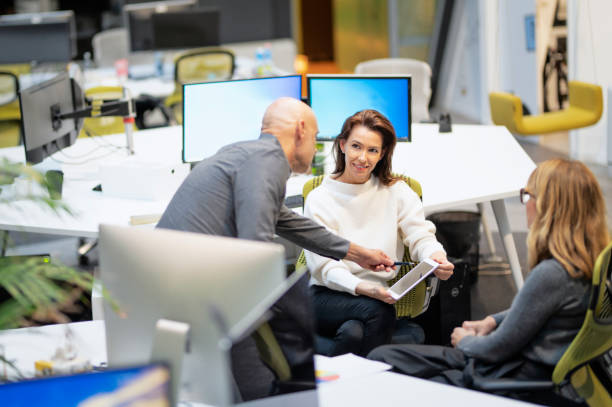 Businesswomen and businessman sitting at the office and discussing business report. Teamwork. stock photo