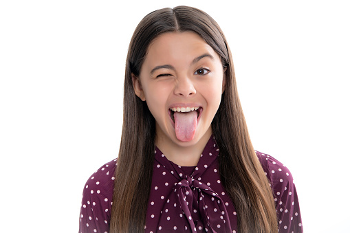 Funny kids face. Portrait of silly teenager child girl smiling and showing tongue in camera making funny faces