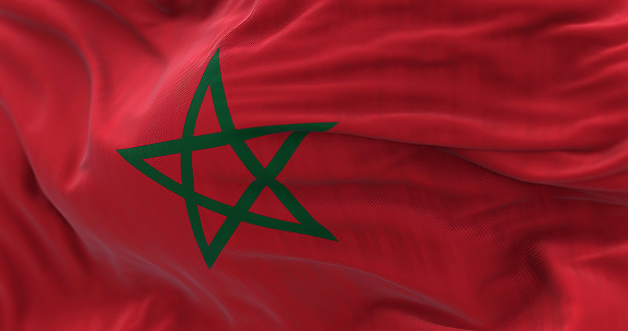 Close-up view of the Morocco national flag waving in the wind. The Kingdom of Morocco is a country in northern Africa. Fabric textured background. Selective focus. 3d illustration