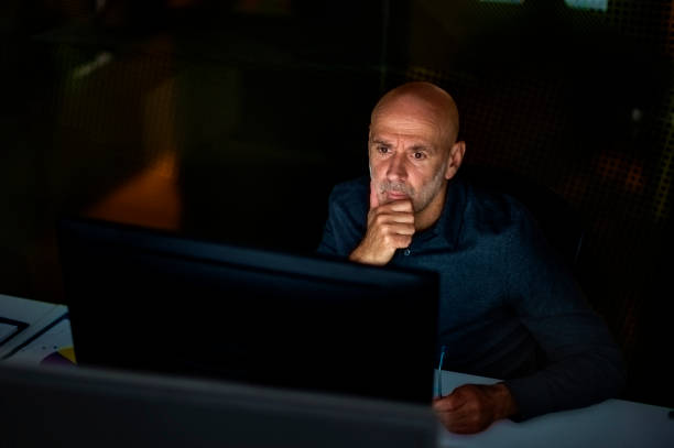 istock Businessman looking thoughtfully while working in late evening at the office 1445412181
