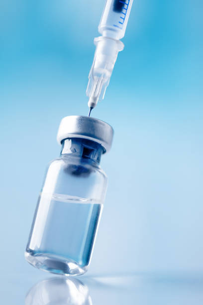 istock Glass vial and syringe with injection over blue background. 1445418775