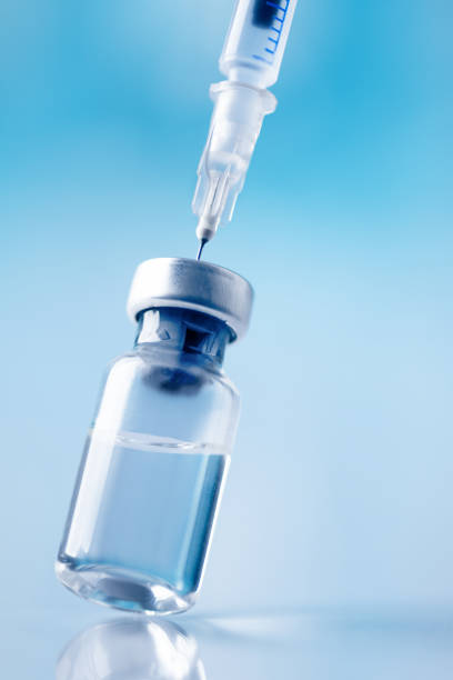 glass vial and syringe with injection over blue background. - syringe vaccination vial insulin imagens e fotografias de stock