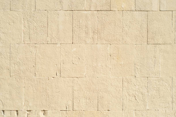 istock Background with a stone wall made of large blocks painted with beige paint 1445419458