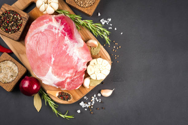istock View above raw boneless pork shoulder ready for roasting with seasoning over dark concrete background with copy space. Organic meat for main dish 1445420535