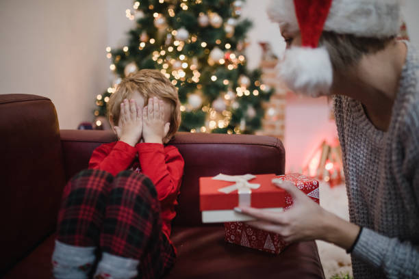 istock Happy mother and son opening Christmas present at home 1445421924