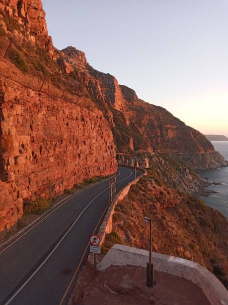 Portrait of Sunset on curvey mountain road Sunset on Chapman's peak drive chapmans peak drive stock pictures, royalty-free photos & images