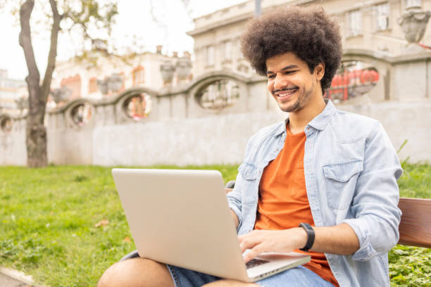 istock Man working on laptop from a park bench 1445423824