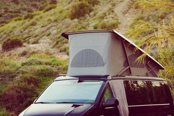 istock Camper van with roof top tent camp on nature 1445425135