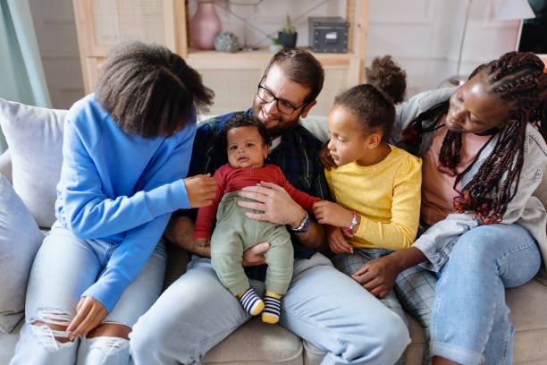 istock Candid portrait young family sitting on sofa 1445427628