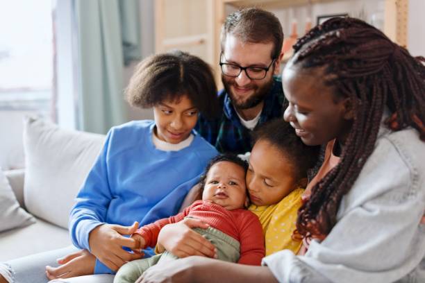 istock Candid portrait young family sitting on sofa 1445427696