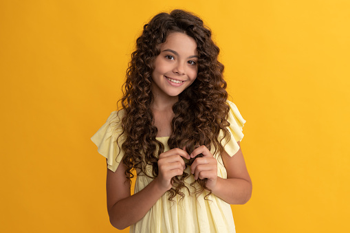 cheerful kid with long curly hair and perfect skin, haircare.
