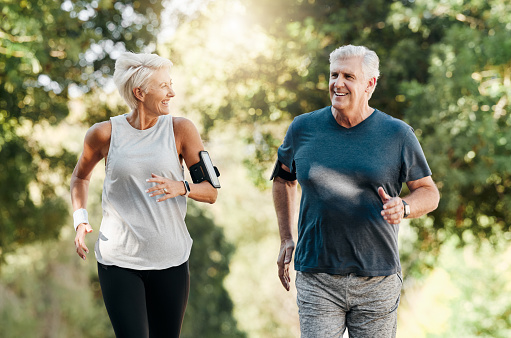 Health, senior couple and hiking in nature or park for exercise, fitness and wellness. Happy, elderly couple and enjoy walk, fresh air and talking in forest for workout, training and relax on holiday