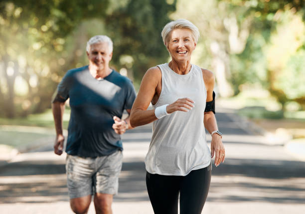 은퇴, 부부 및 달리기 피트니스 건강 자연적인 노화와 함께 몸과 심장 건강을 위해. 기혼, 장년 및 노인은 심혈관 활력 운동을 위해 함께 자연 달리기를 즐깁니다. - running cheerful outdoors senior couple 뉴스 사진 이미지