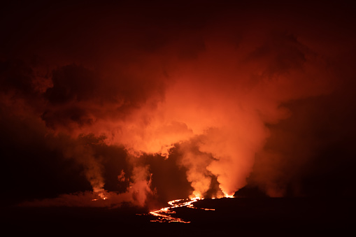 Fountains of lava erupt from Mauna Loa at night  as volcanic gases fill the sky