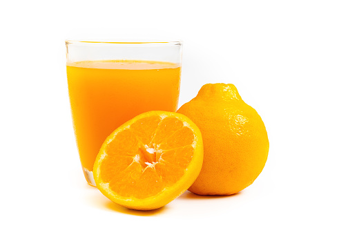 Front  view of orange fruit and glass of orange juice