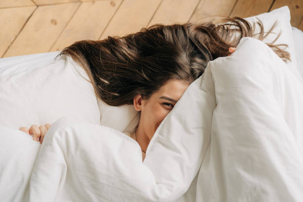 istock Young woman in home interior, lying in bed. 1445438131