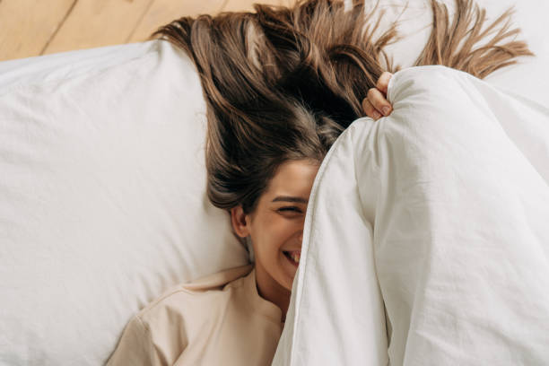 istock Young woman in home interior, lying in bed. 1445438137
