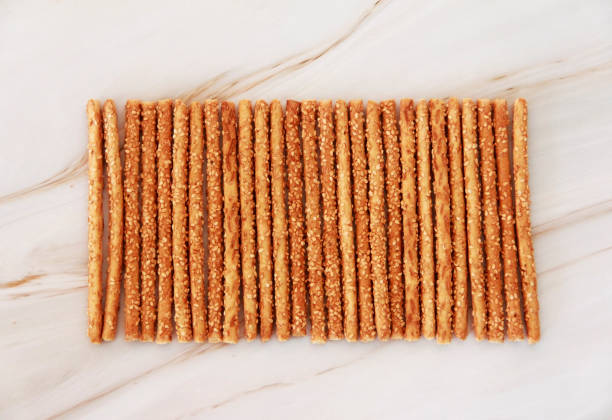 baked dry long bread sesame sticks on a marble background