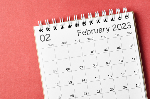 A February 2023 calendar desk for the organizer to plan and reminder isolated on red background.