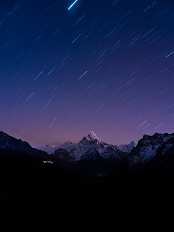 Stars streaking over the snow capped peak of Ama Dablam 6812m deep in the Himalaya mountains of Nepal.