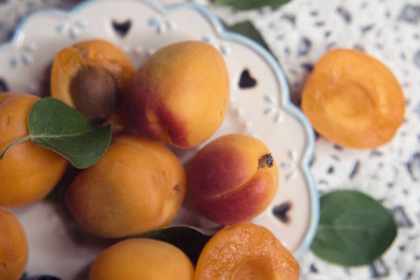 apricots on a carved plate and a lace napkin on a light background