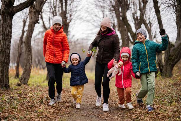 istock Mother holding hands with her kids running in autumn forest. 1445455679