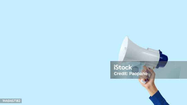 Megaphone In Woman Hand On Blue Background Creative Announcement Concept Stock Photo - Download Image Now