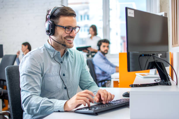 istock Young male technical support dispatcher in call center. Man in call center with headset helping customer. 1445457461