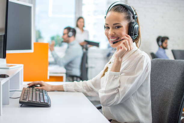 istock Positive female customer services agent with headset working in call center. 1445457608