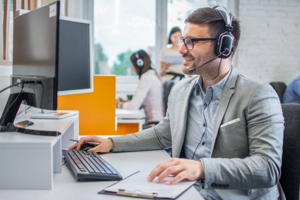 istock Smiling customer service executive with headset working in call center. 1445459281