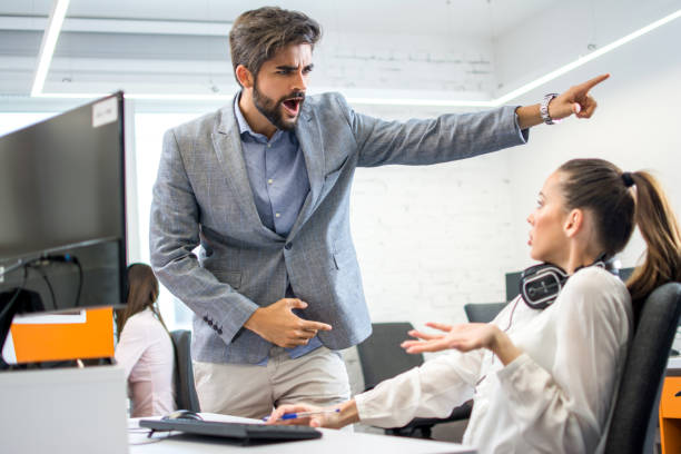 zły szef wypalania zdenerwowany kobieta pracownik w biurze. młody mężczyzna business manager krzyczy na przestraszony i podkreślił kobiet biznesu w jej miejscu pracy. - arguing business person harassment people zdjęcia i obrazy z banku zdjęć