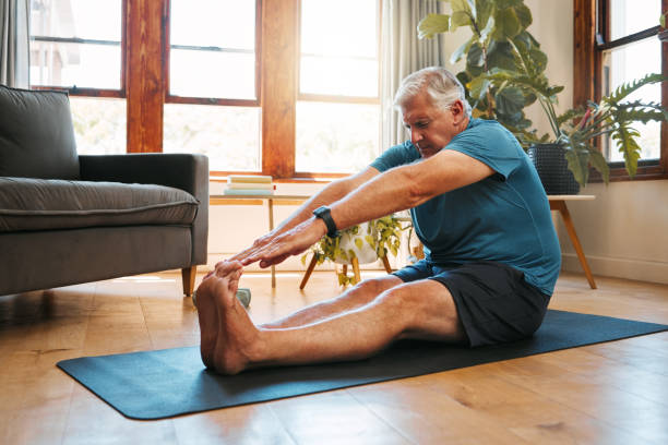 gesundheit, bewegung und yoga mit älteren männern, die sich vor meditation und wellness-training dehnen. fitness, entspannung und bodenaufwärmung durch ältere männer beginnen gesundes cardio-training im wohnzimmer - senior adult sport yoga exercising stock-fotos und bilder