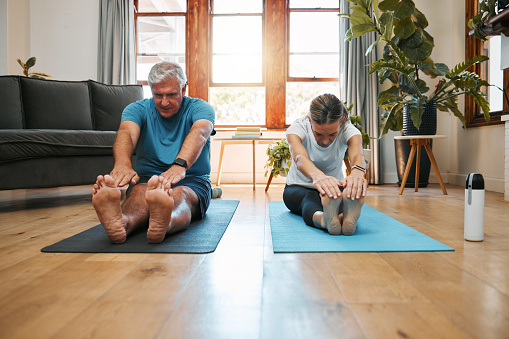 Yoga stretching, home workout and mature couple fitness in living room for wellness, exercise and healthy lifestyle in Australia. Senior man, relax woman and pilates training, energy and strong body