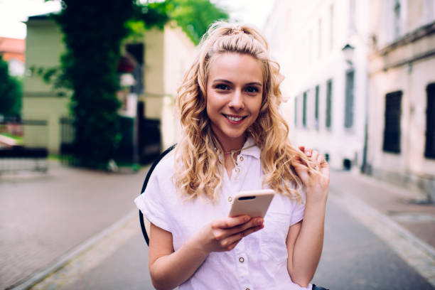 istock Charming female browsing mobile on street 1445460868