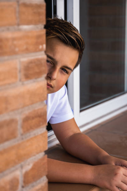 istock Cool teen boy looking out window 1445462625