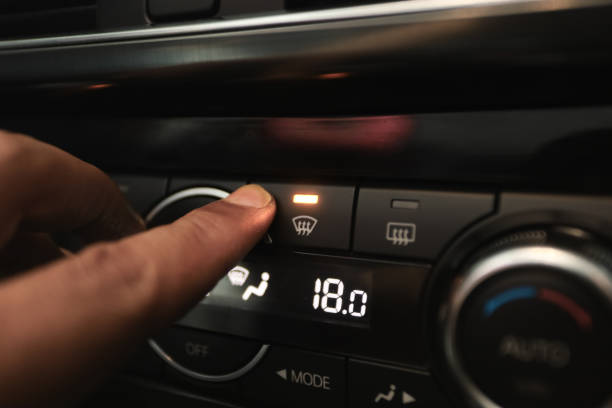 Windshield Defogger Icon on Car.  hand pressing the defogger button to remove the fog on the windshield